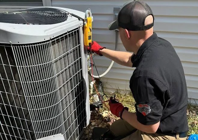 Technician wearing red gloves checking an outdoor air conditioner